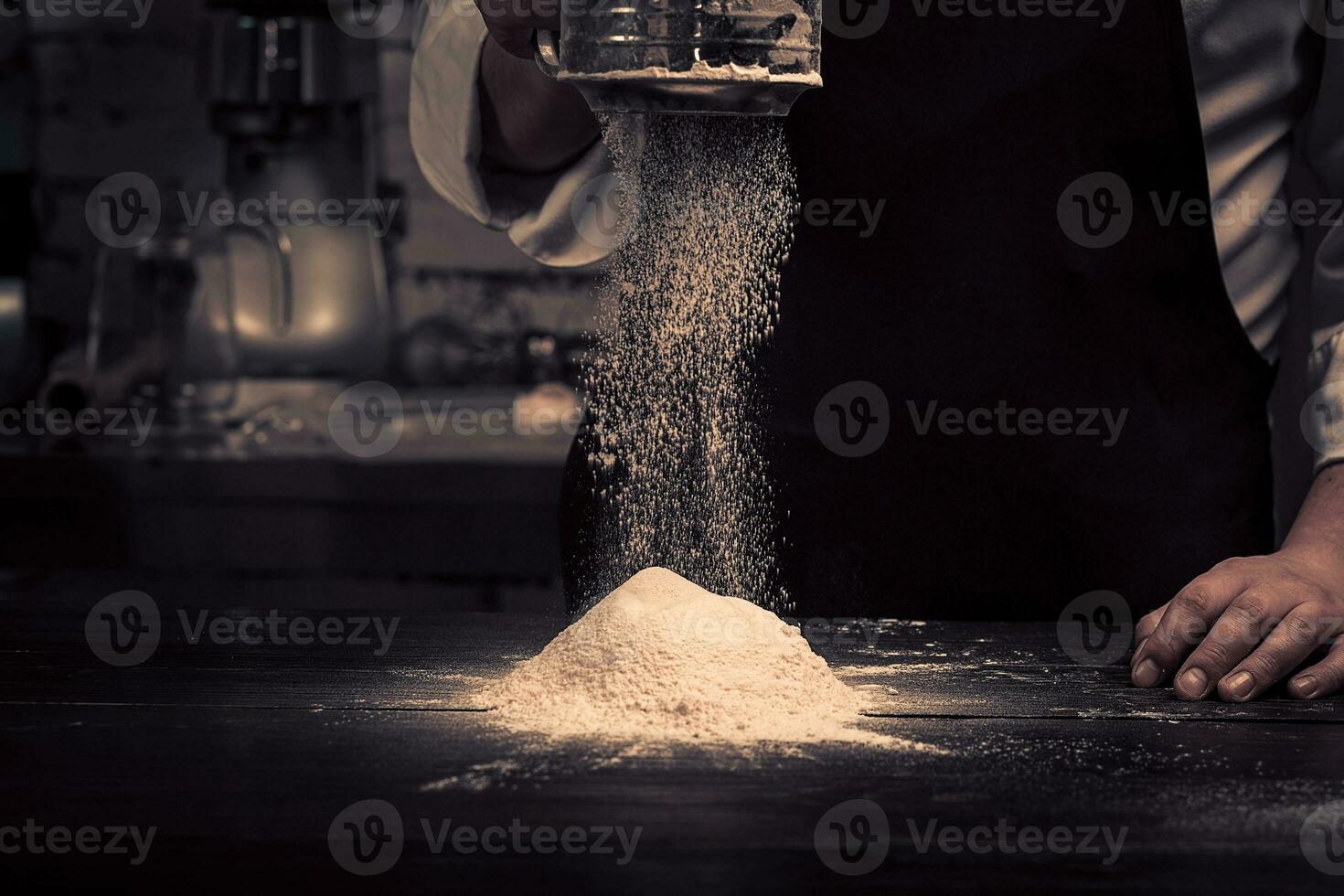the chef hands are dropping flour over a wooden table photo