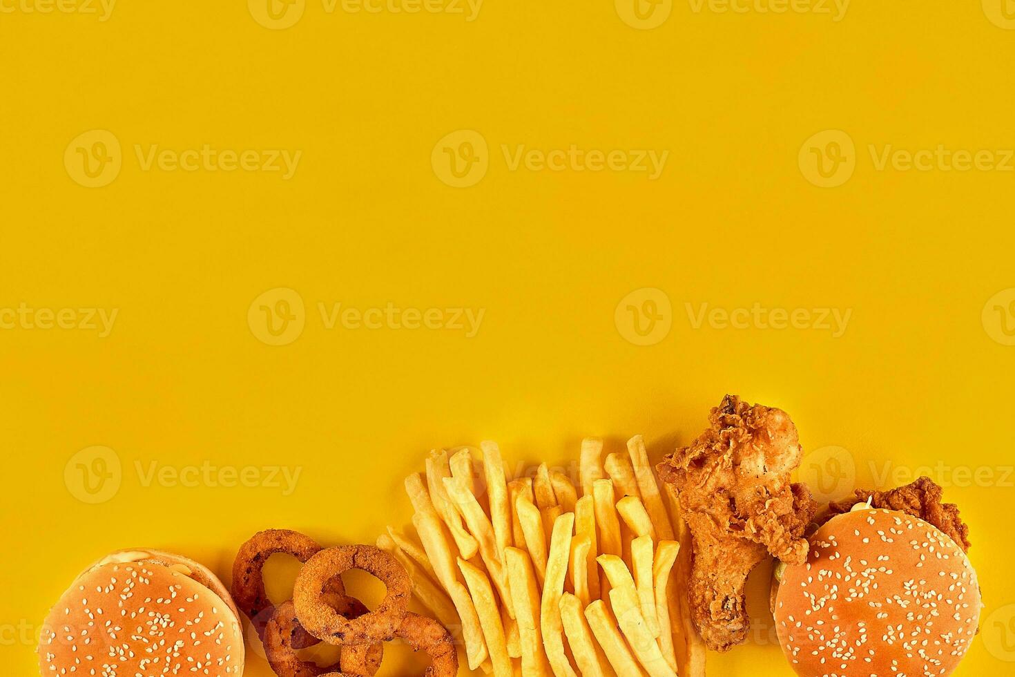 Fast food dish on yellow background. Fast food set fried chicken, meat burger and french fries. Take away fast food. photo