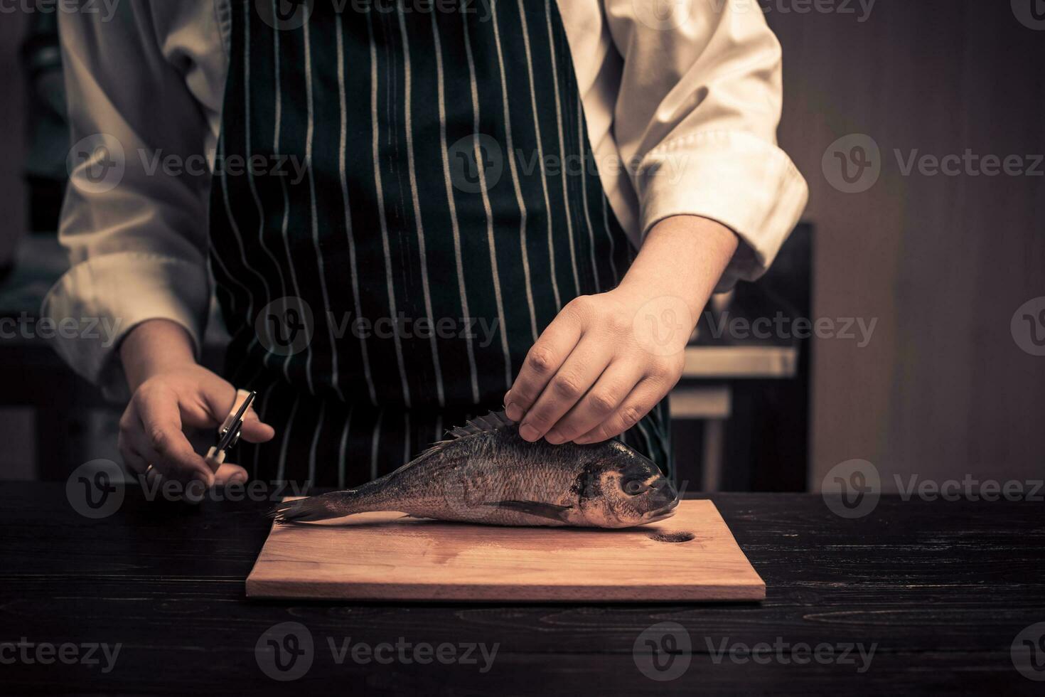 Chef cutting the fish on a board photo