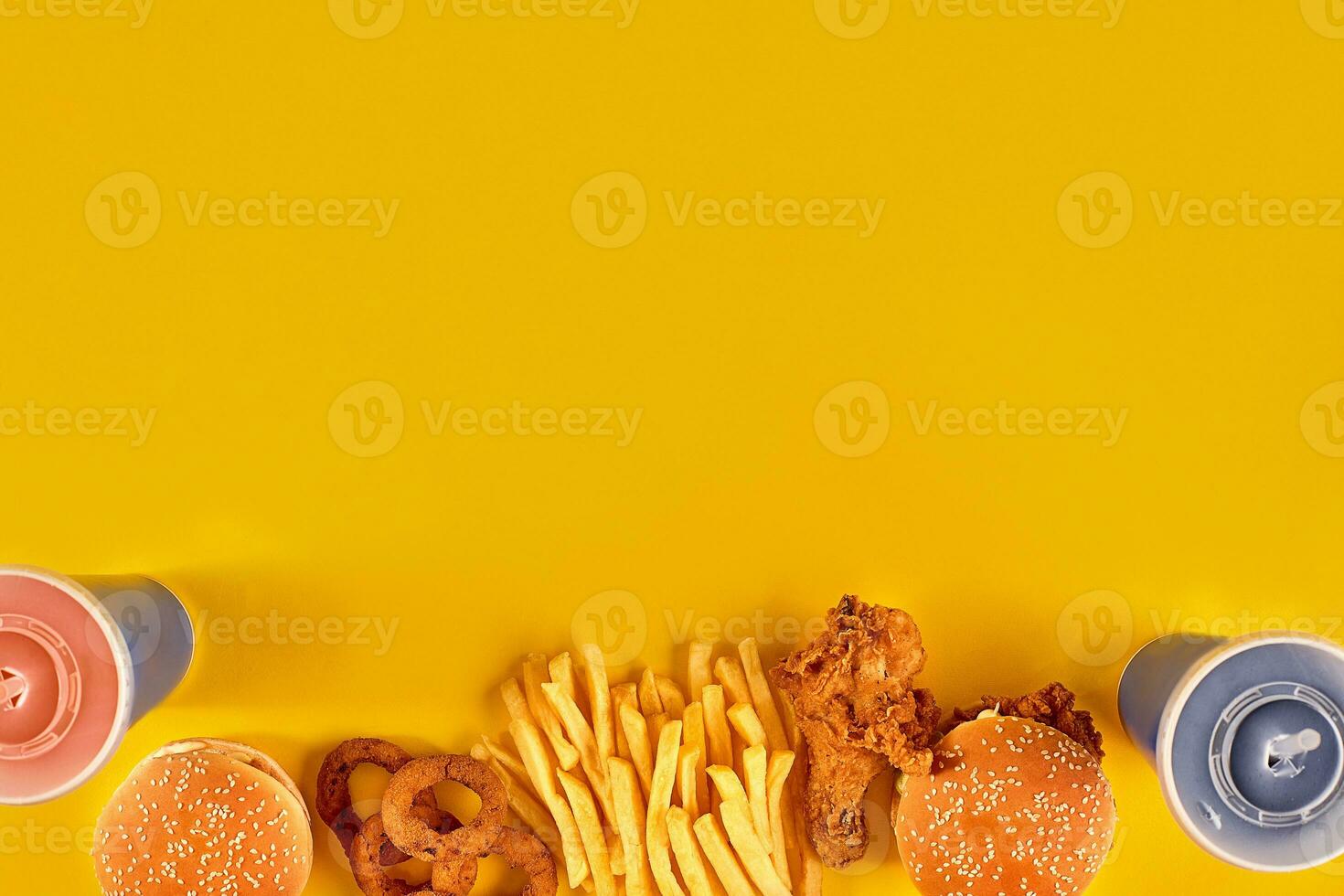 Fast food dish on yellow background. Fast food set fried chicken, meat burger and french fries. Take away fast food. photo