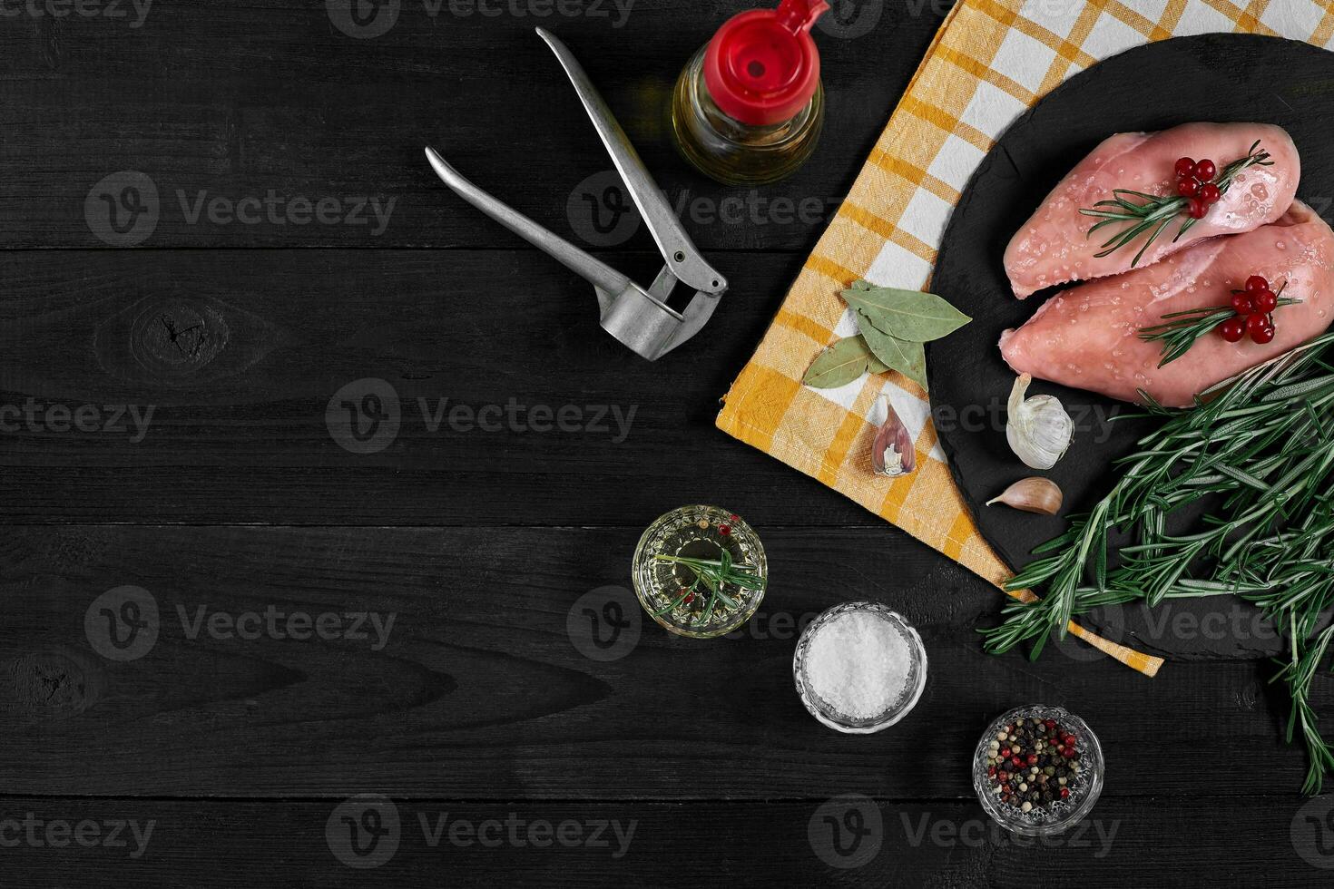 Raw chicken fillet with cooking ingredients on black slate table. Food background. Top view, copy space. photo