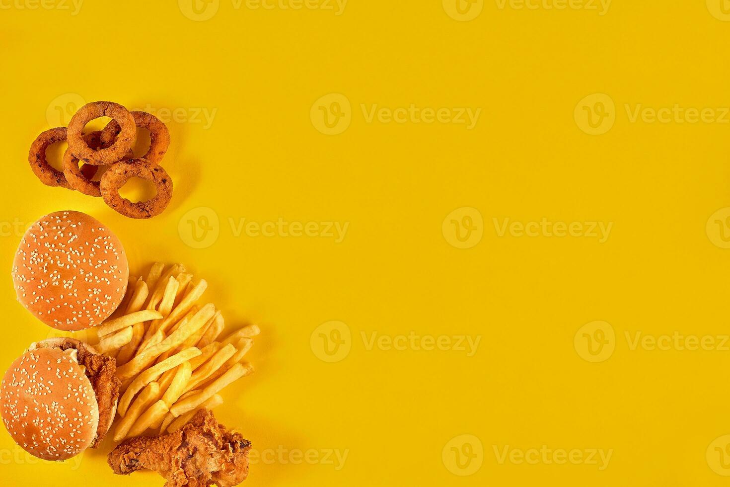 Fast food dish on yellow background. Fast food set fried chicken, meat burger and french fries. Take away fast food. photo