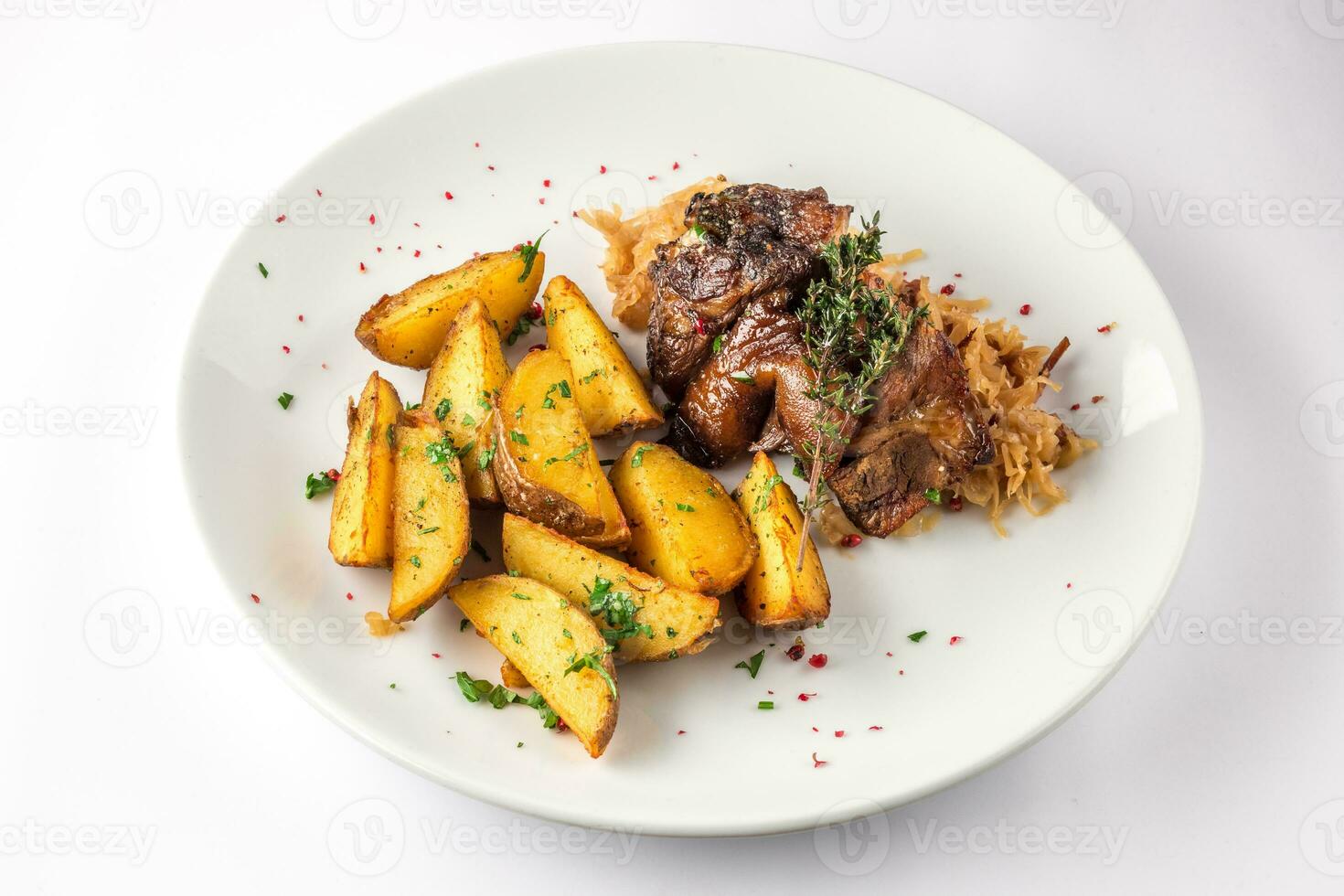 Pork knuckle with potatoes and cabbage on a white plate. Selective focus. photo