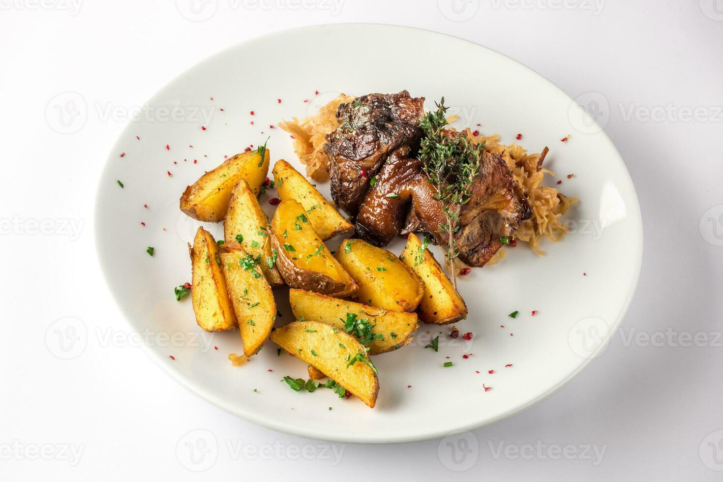 Pork knuckle with potatoes and cabbage on a white plate. Selective focus. photo