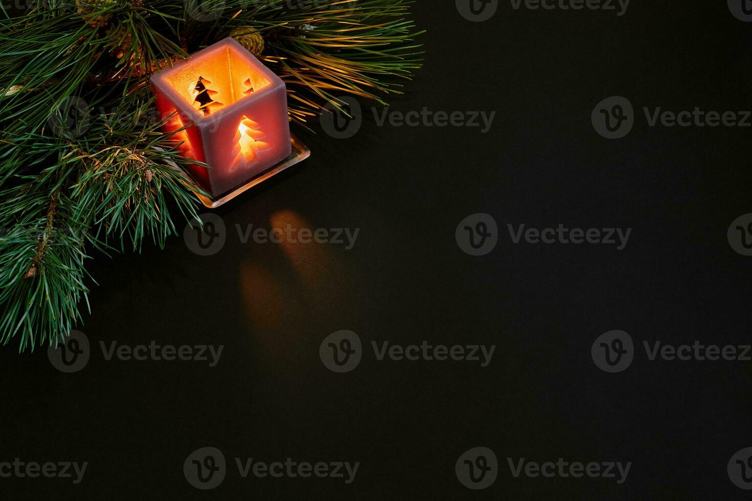 Christmas, christmas tree, candle, cones and cinnamon sticks on black background photo