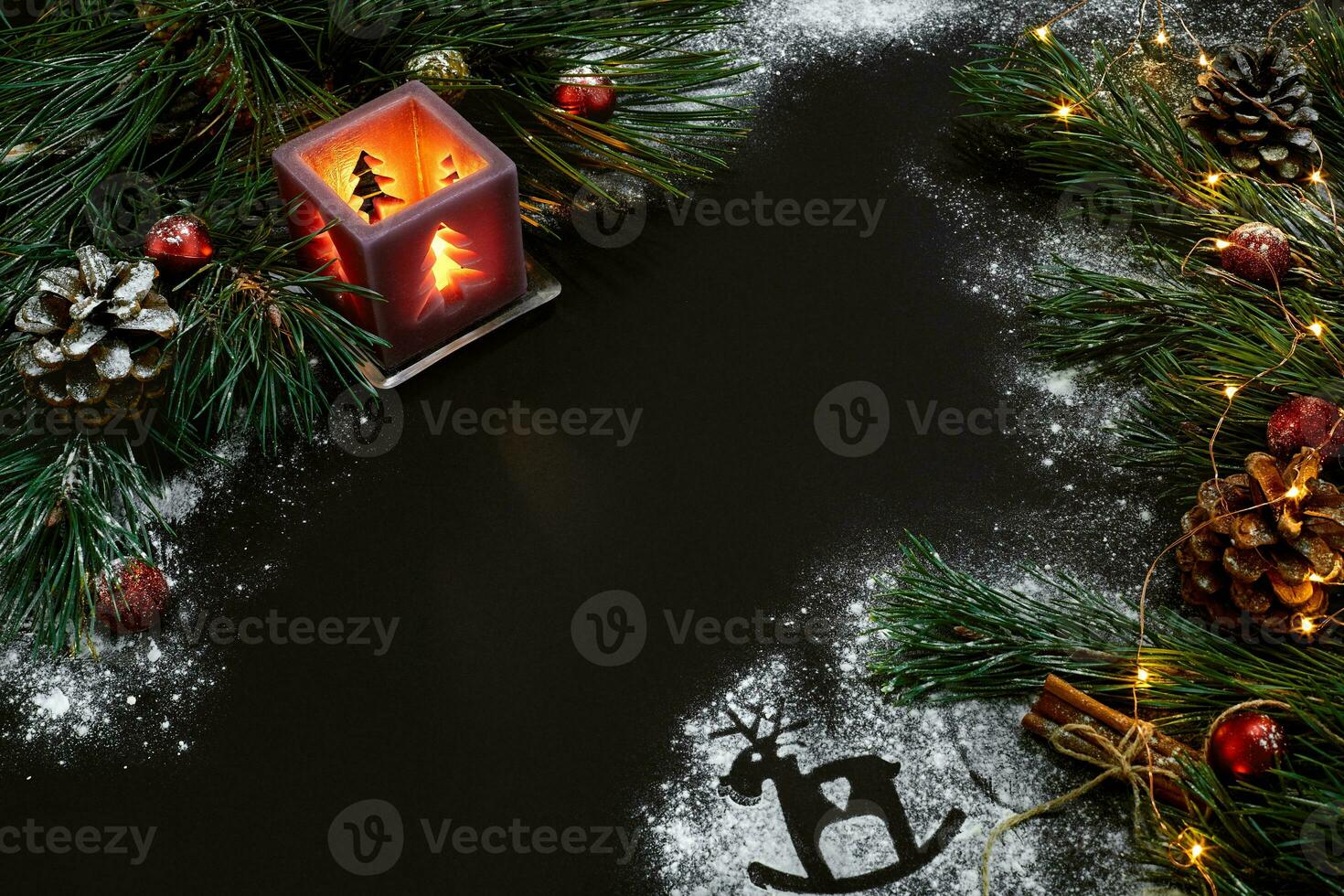 Christmas, christmas tree, candle, snow, cones and cinnamon sticks on black background photo