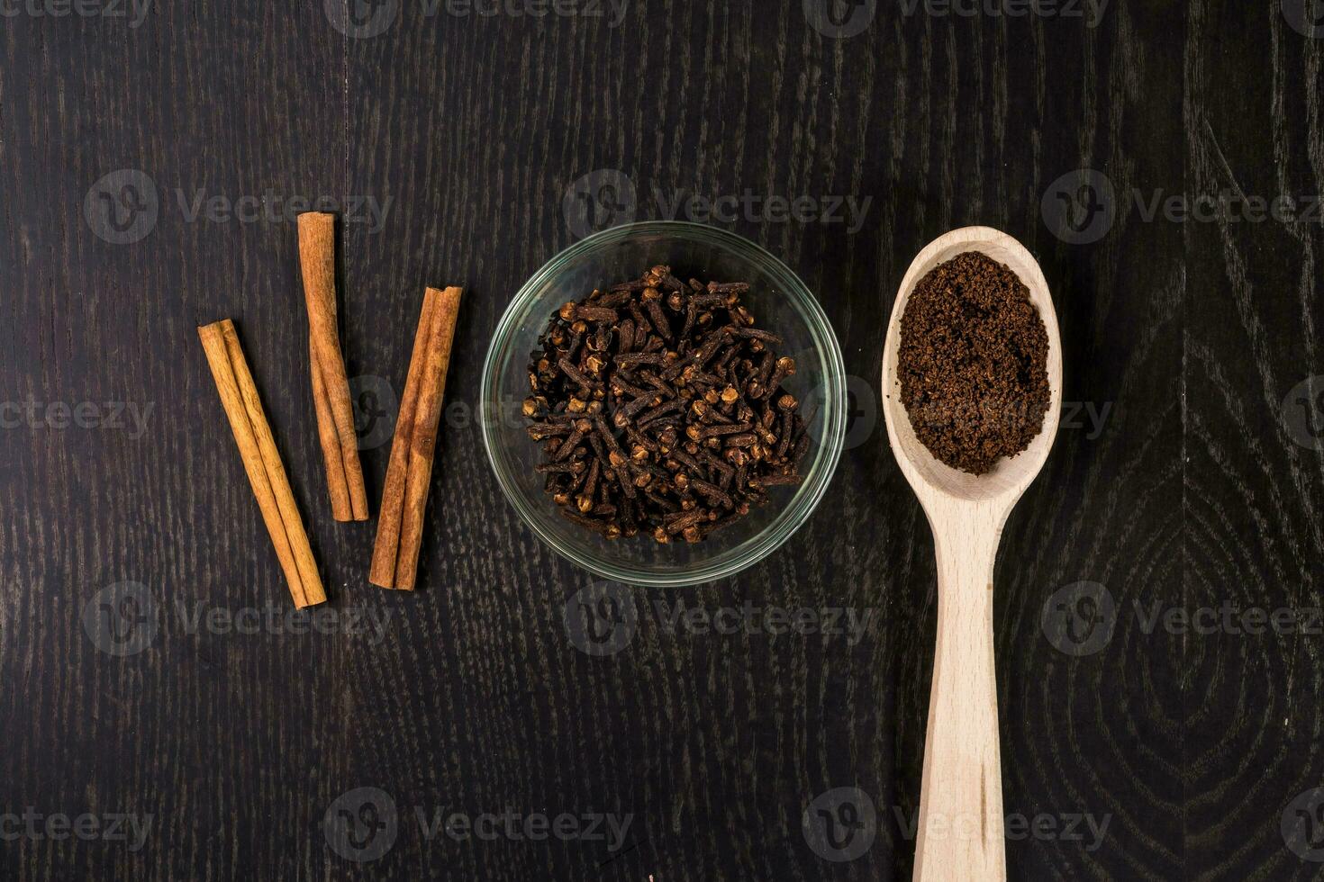 canela palos, café, clavos de olor en negro antecedentes foto