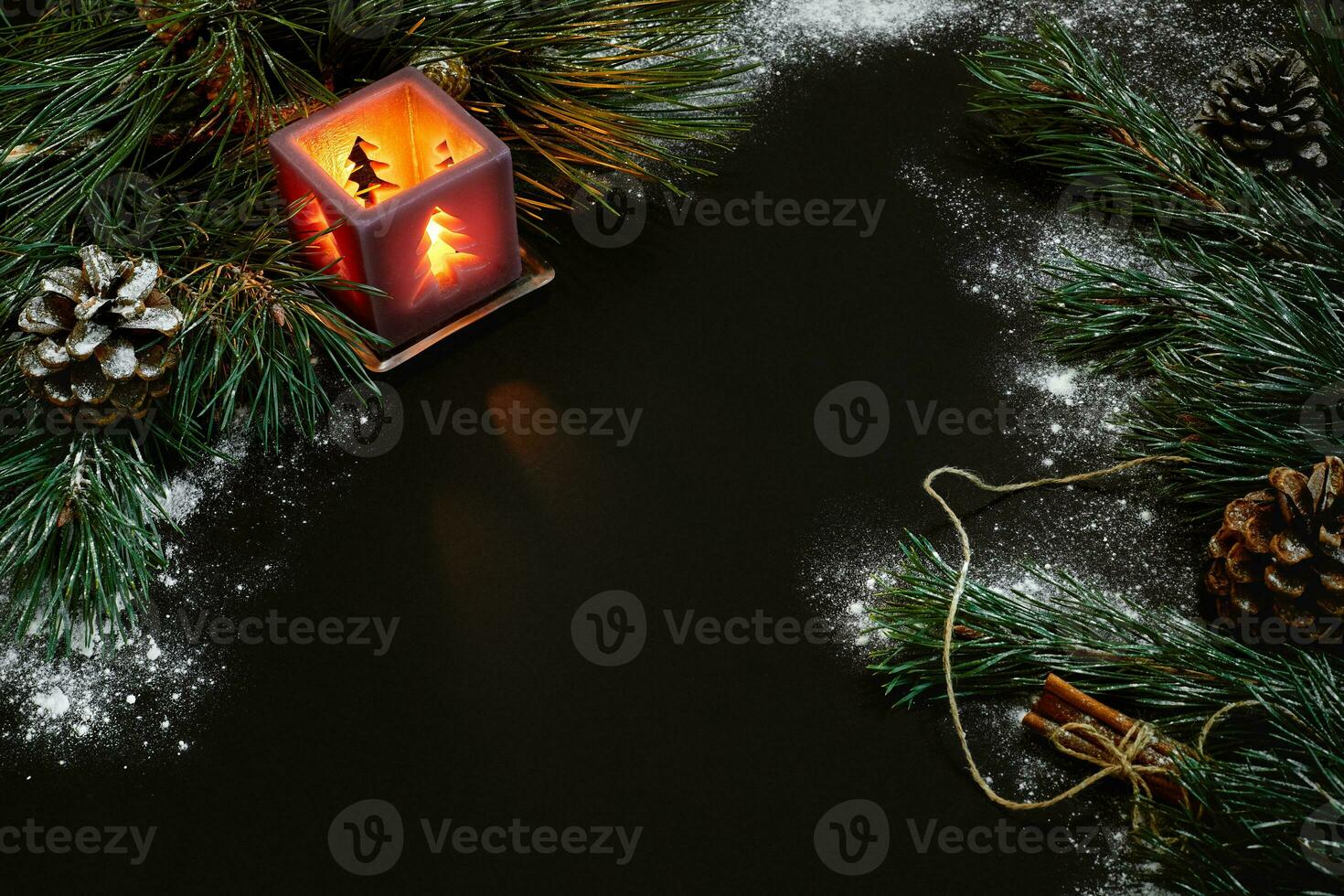 Christmas, christmas tree, candle, snow, cones and cinnamon sticks on black background photo