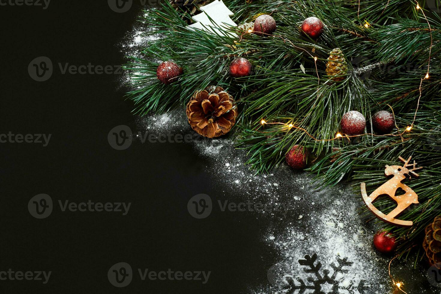 Christmas. Xmas toys and spruce branch on black background top view. Space for text photo