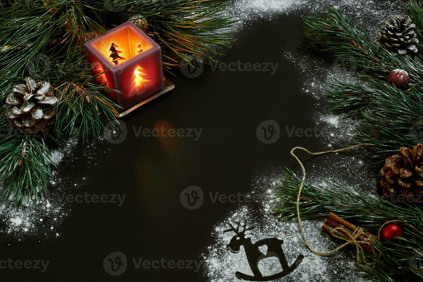 Christmas, christmas tree, candle, snow, cones and cinnamon sticks on black background photo