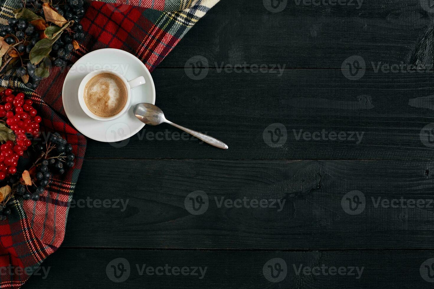 White cup of the coffee and vintage scarf on black wooden background photo