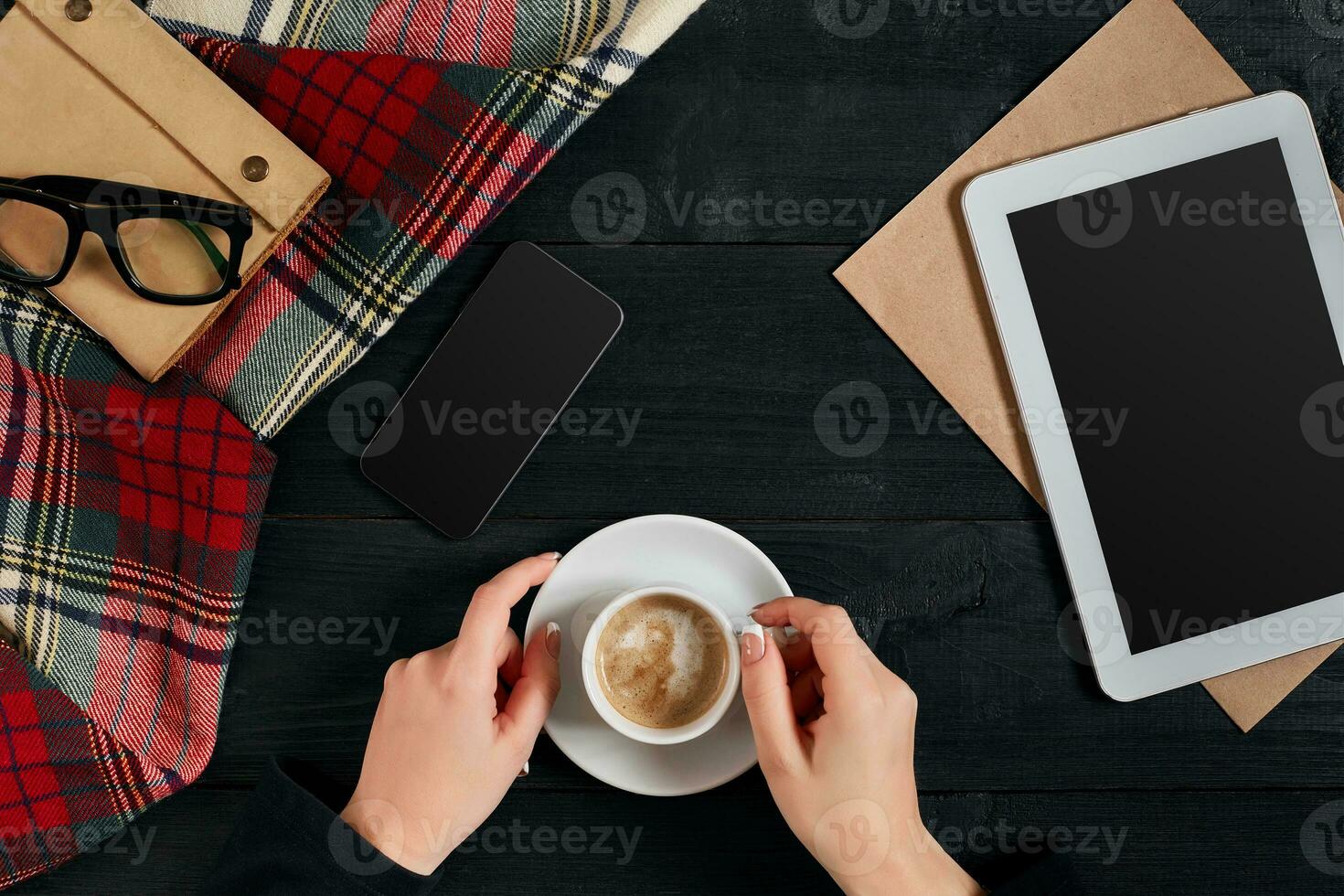 Woman holding cup of coffee and using a digital tablet on a wooden table, technology and communication concept, flat lay photo