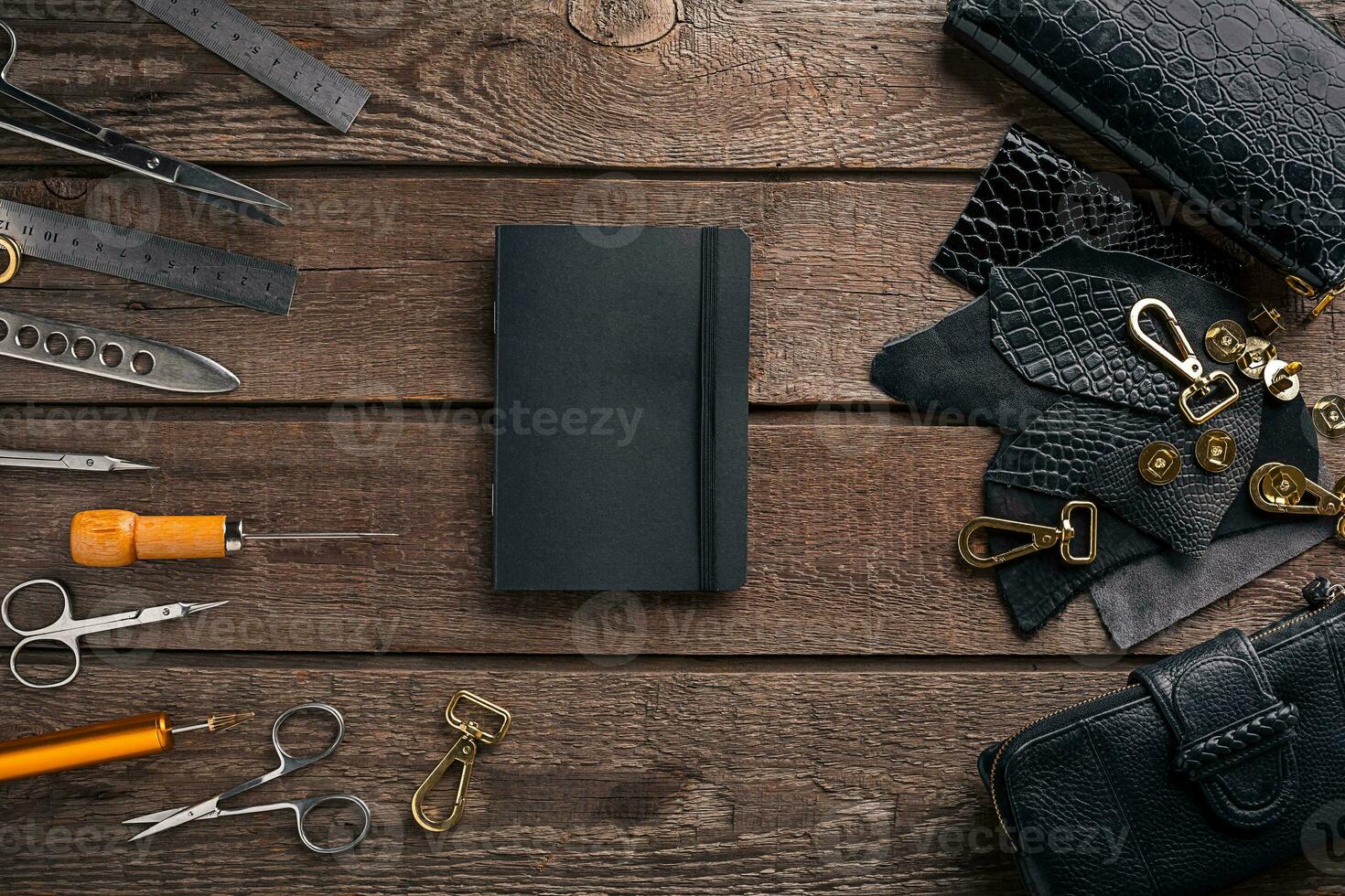 Leather craft or leather working. Leather working tools and cut out pieces of leather on work desk . photo