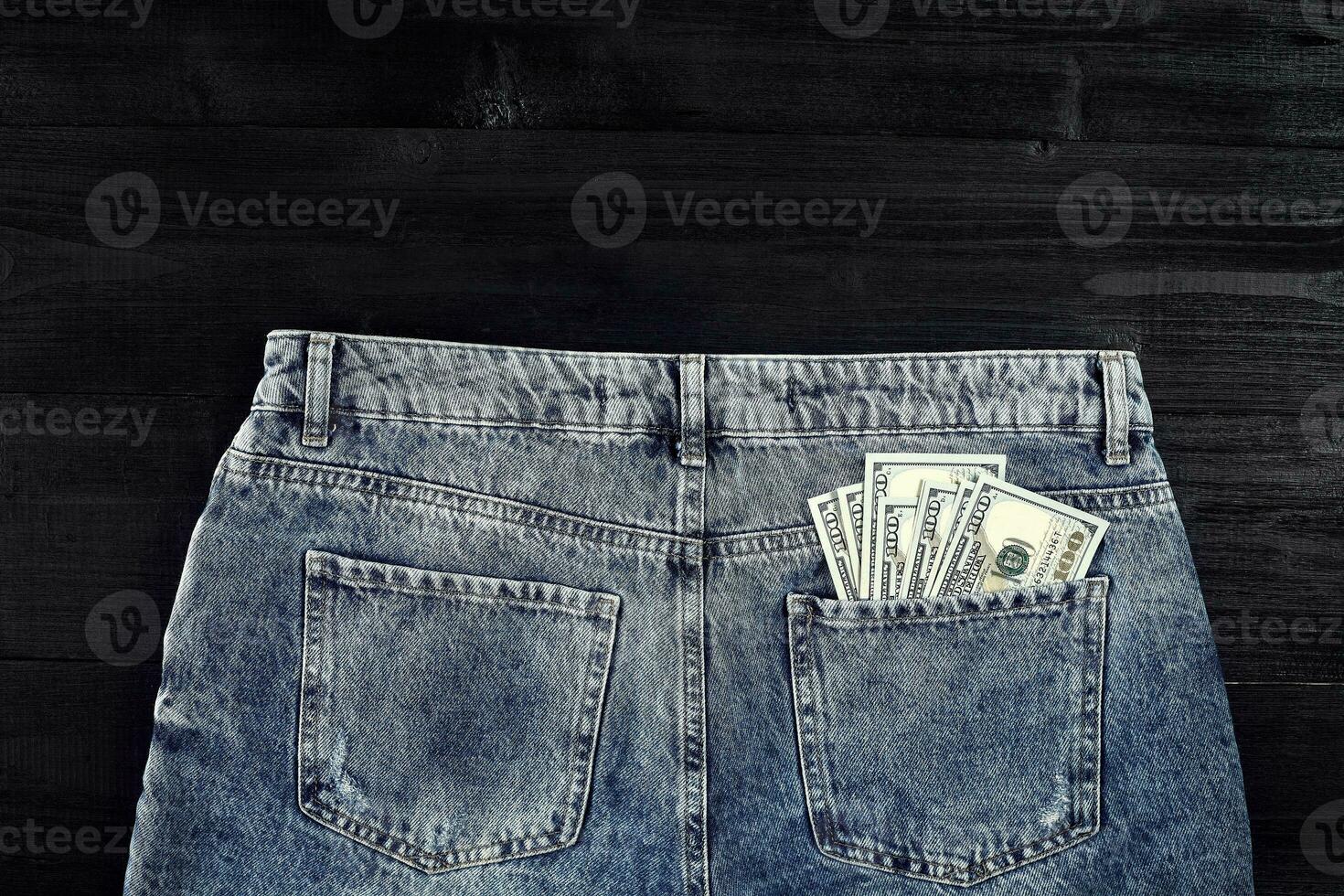 Pocket money. Dollar in hip pocket of worn blue jeans. Close-up. photo