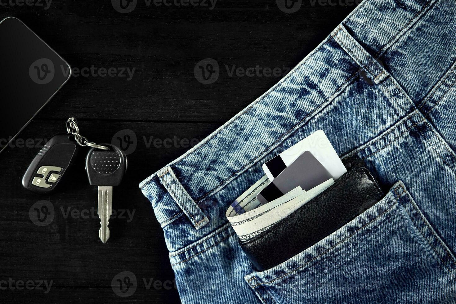 Money, Debit card and Credit card are in pocket of blue jean, Car keys, Smart on wooden background with copy space. photo