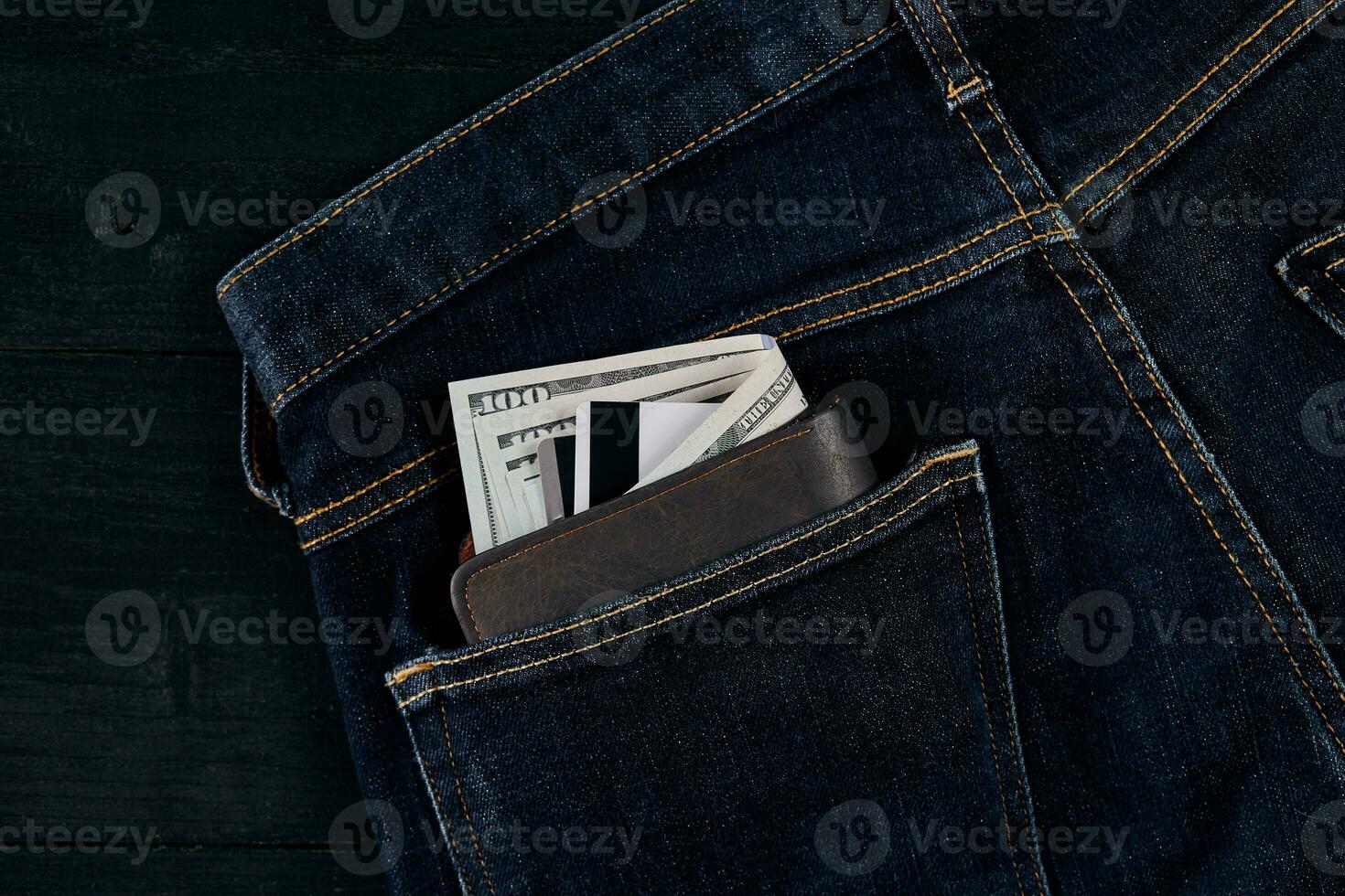 Money in pocket of blue jean on wooden background with copy space. photo