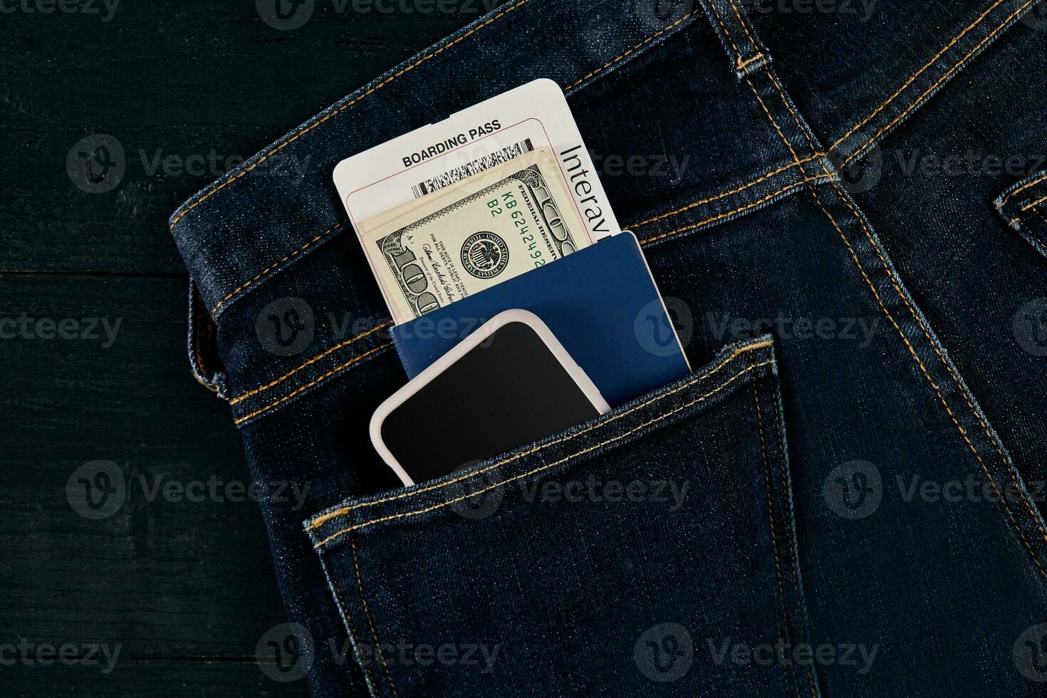 Dollars, smart, passport and plane ticket in your pocket jeans. photo