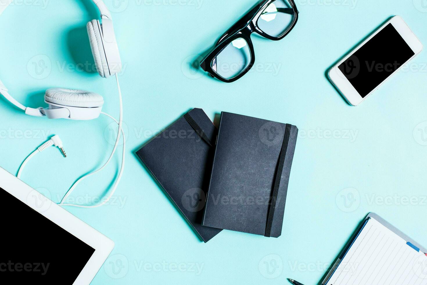 Working place with tablet, smartphone and glasses on a turquoise background photo