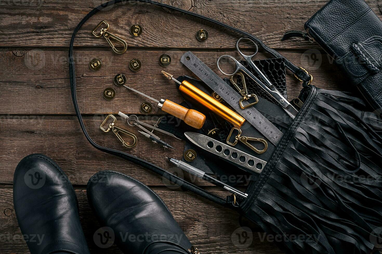 Leather craft or leather working. Leather working tools and cut out pieces of leather on work desk . photo
