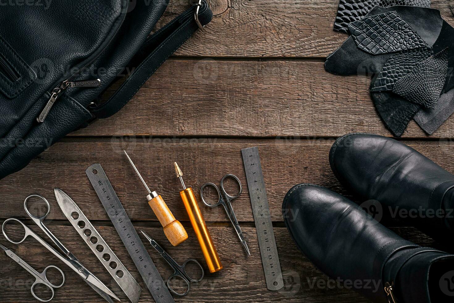 Leather craft or leather working. Leather working tools and cut out pieces of leather on work desk . photo