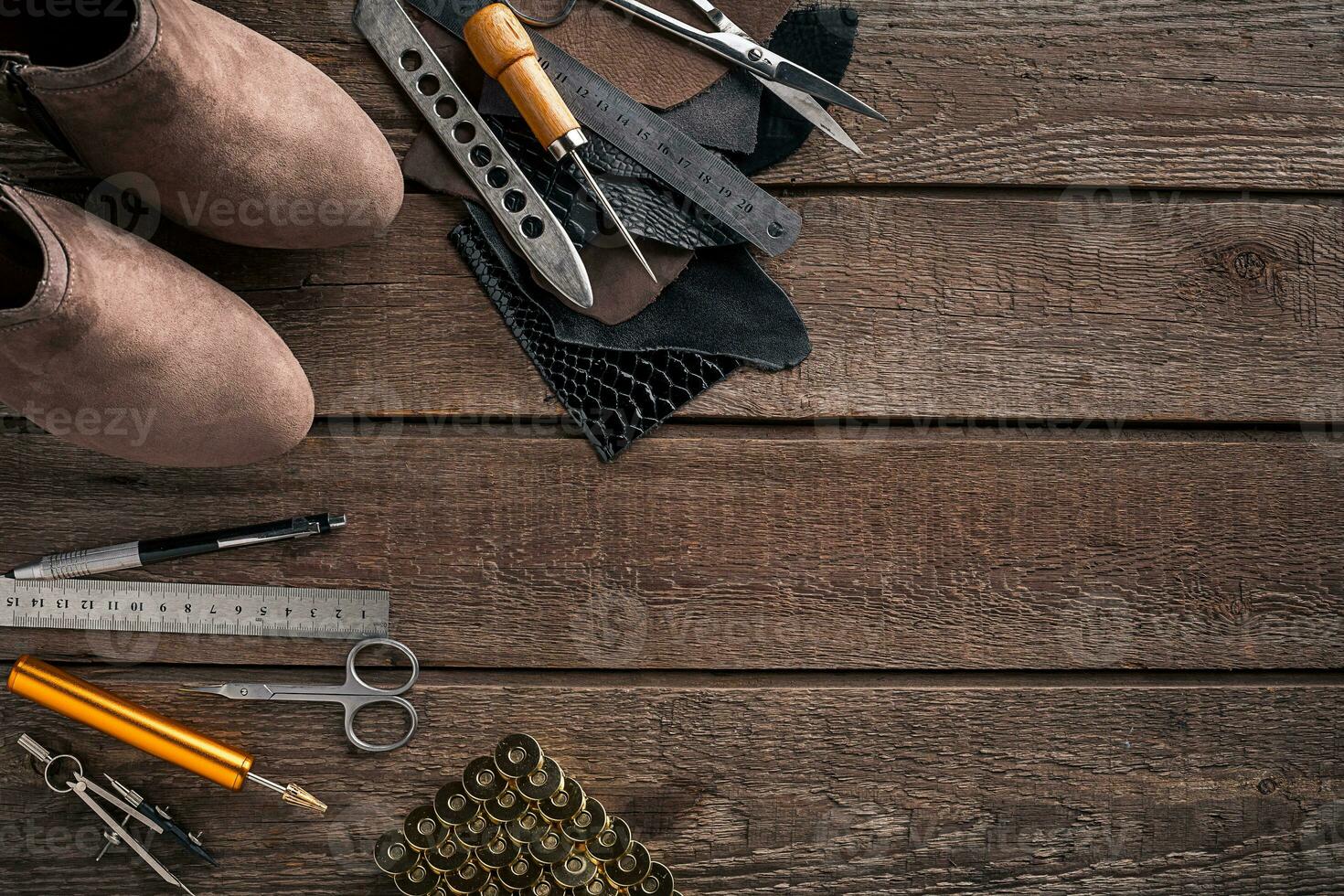 Leather craft or leather working. Leather working tools and cut out pieces of leather on work desk . photo