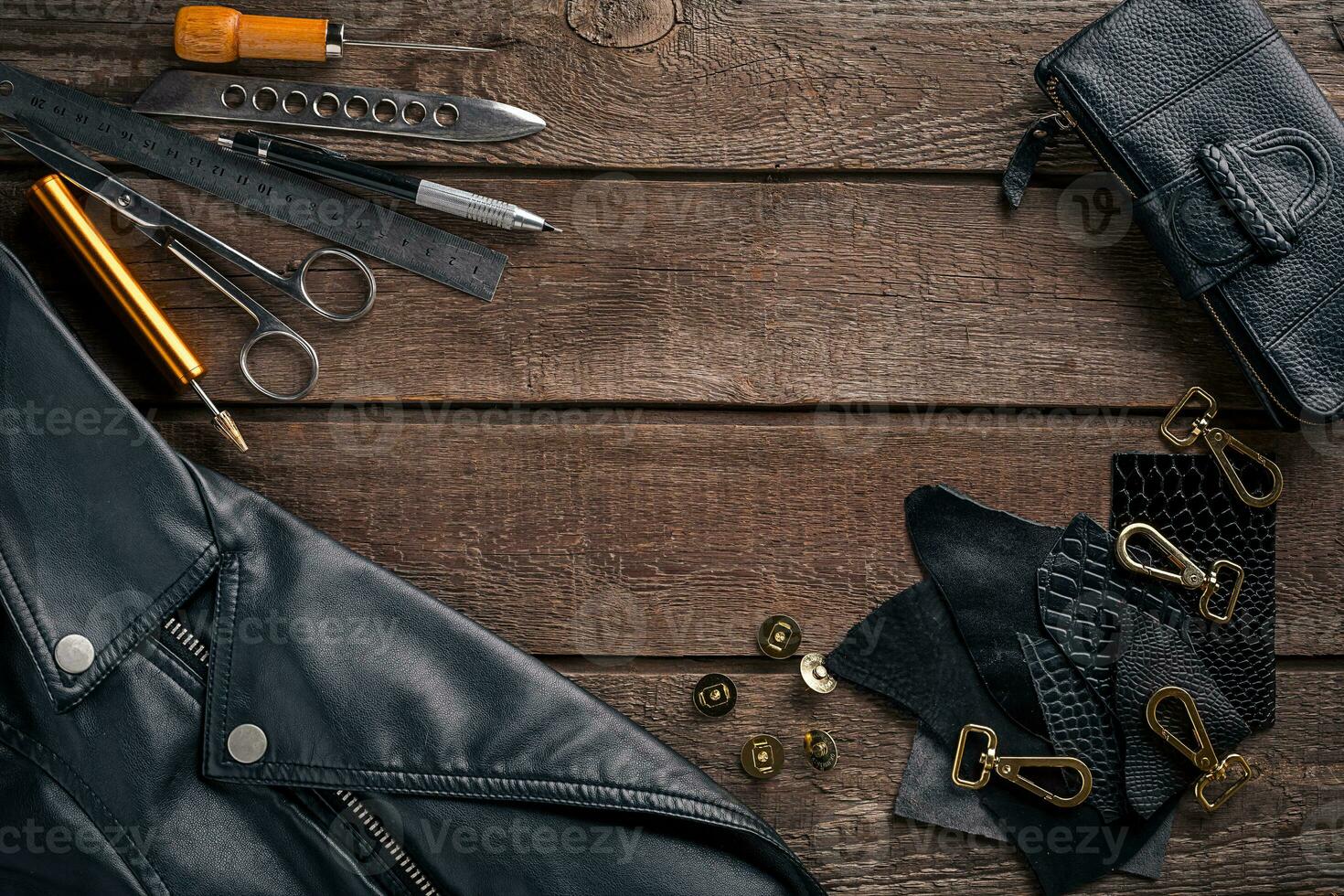 Leather craft or leather working. Leather working tools and cut out pieces of leather on work desk . photo