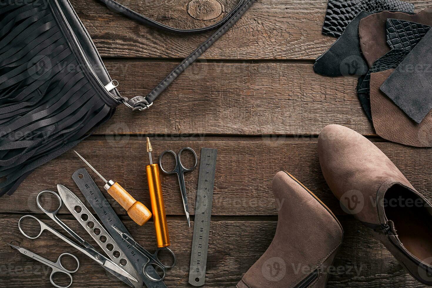 Leather craft or leather working. Leather working tools and cut out pieces of leather on work desk . photo