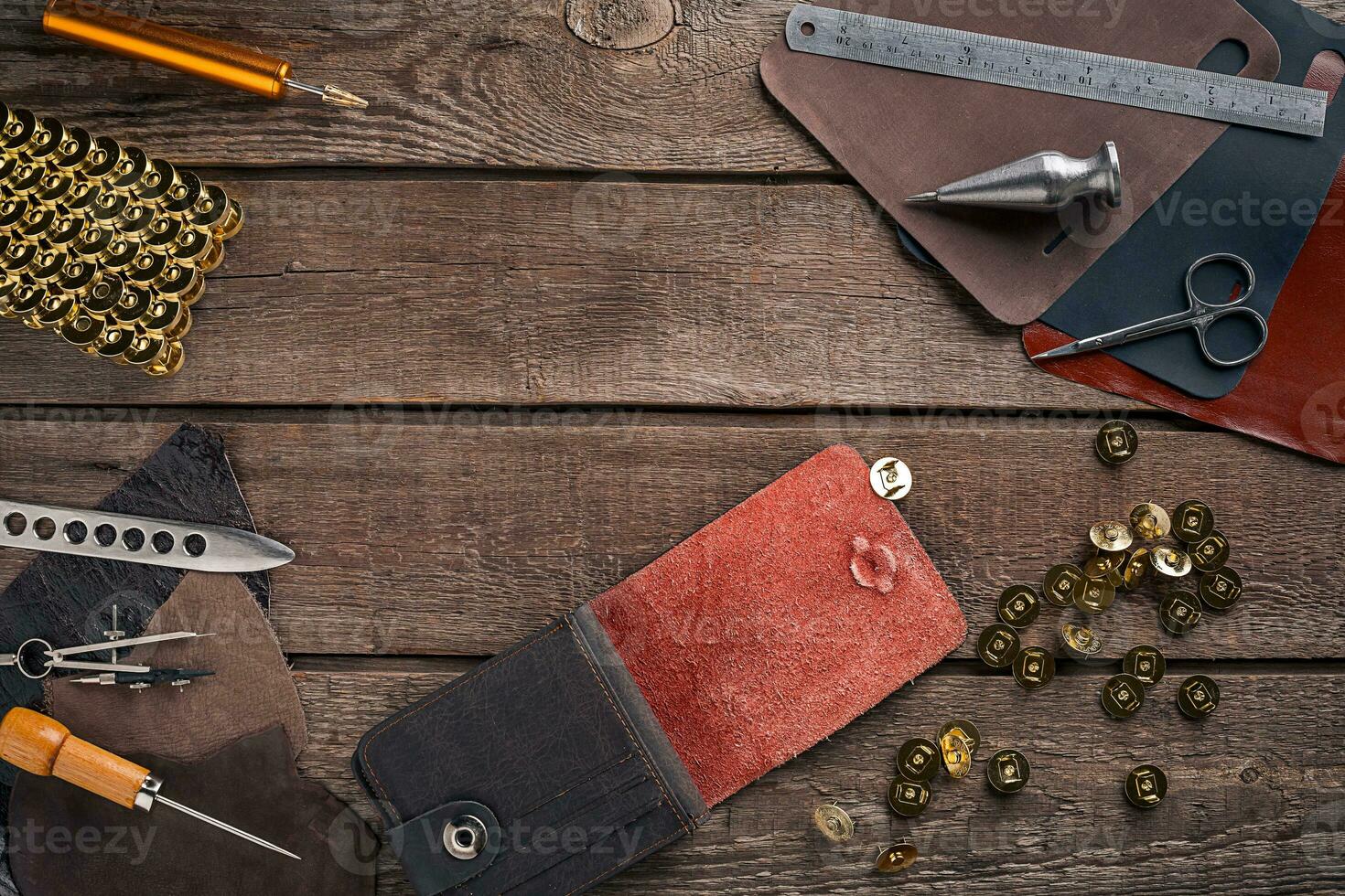 Leather craft or leather working. Leather working tools and cut out pieces of leather on work desk . photo