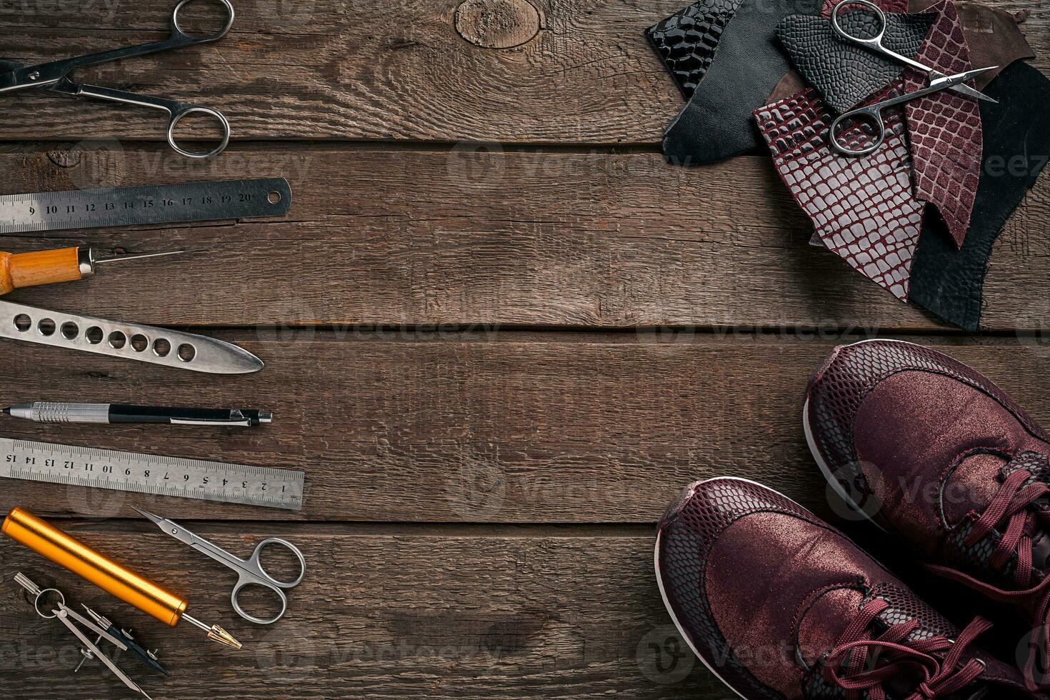 Leather craft or leather working. Leather working tools and cut out pieces of leather on work desk . photo