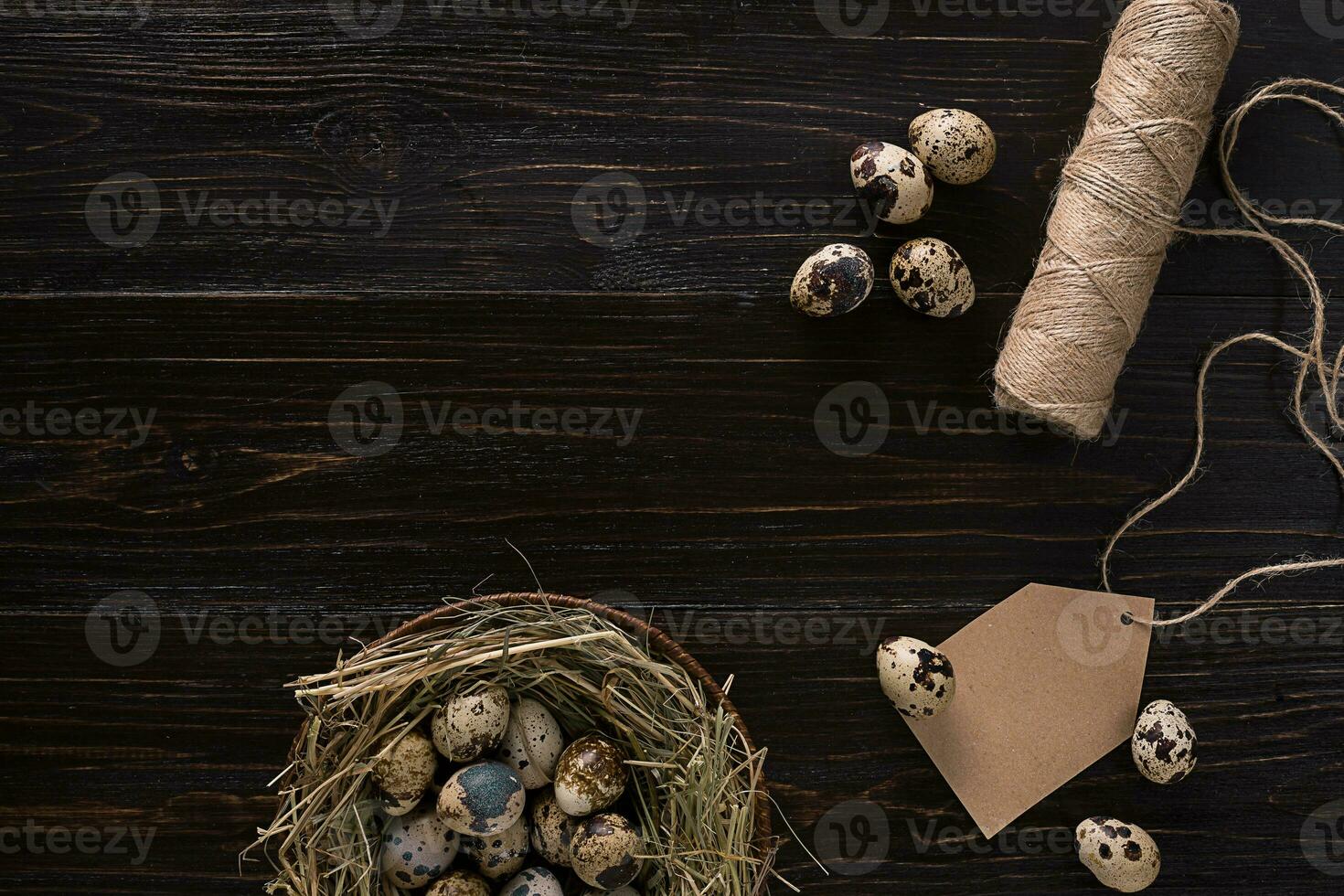 quail eggs in a nest, place for text on wooden rustic background top view close up photo