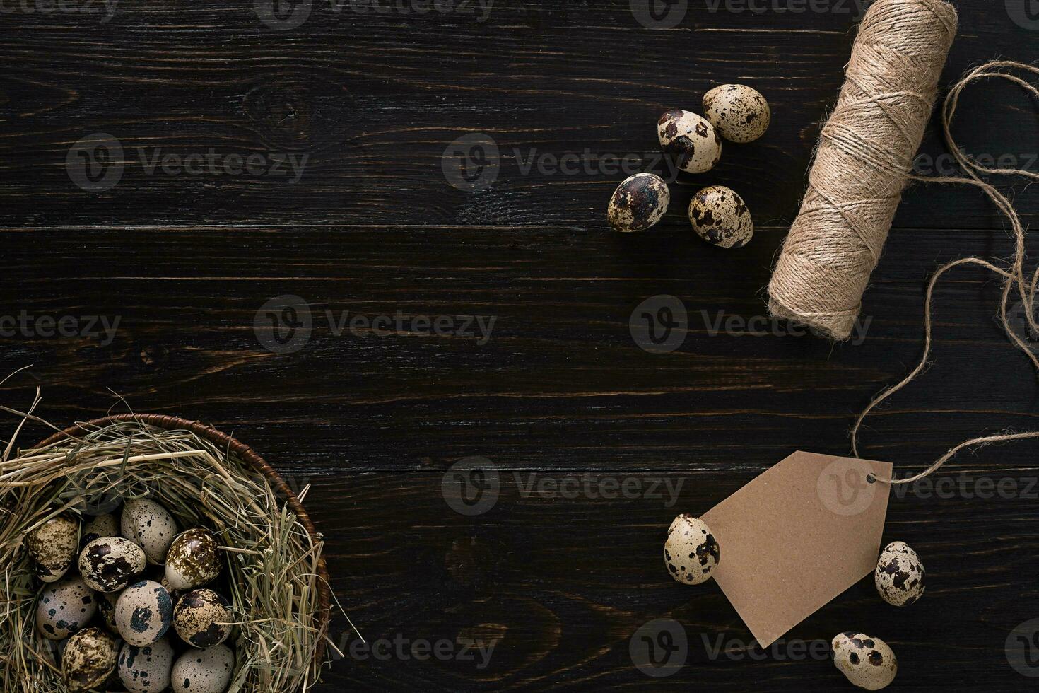quail eggs in a nest, place for text on wooden rustic background top view close up photo