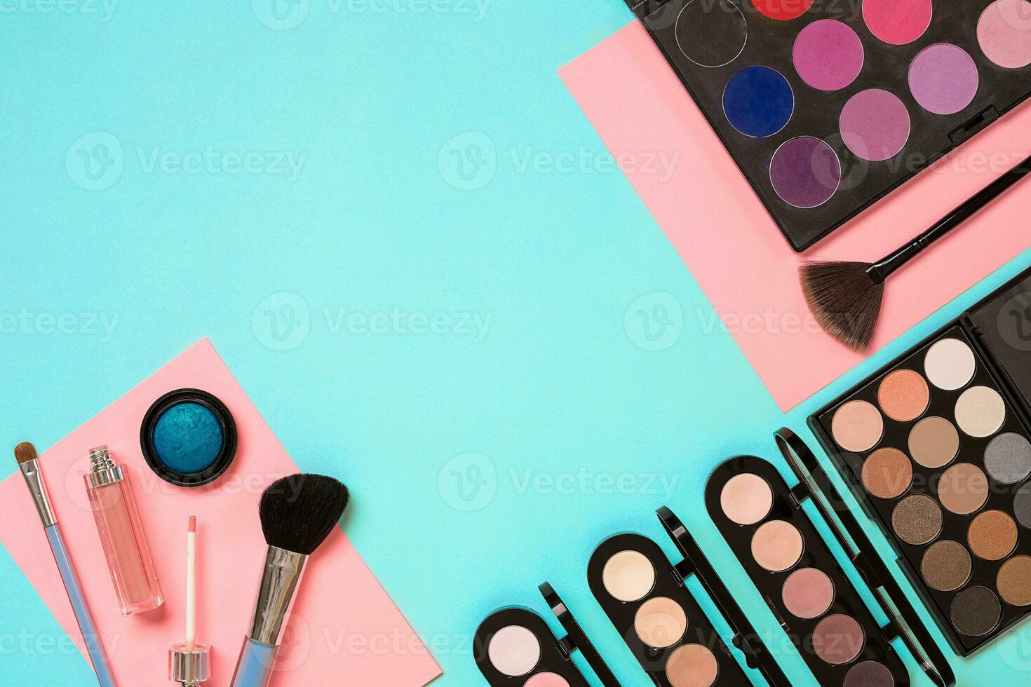 Make up essentials. Set of professional make up brushes, creams and shadows in jars on blue background. photo