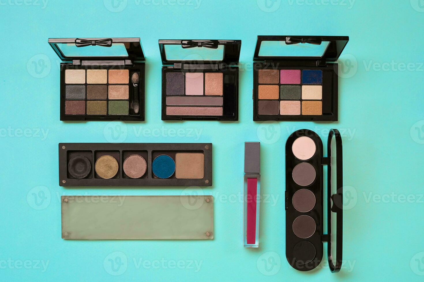 Make up essentials. Set of professional make up brushes, creams and shadows in jars on blue background. photo