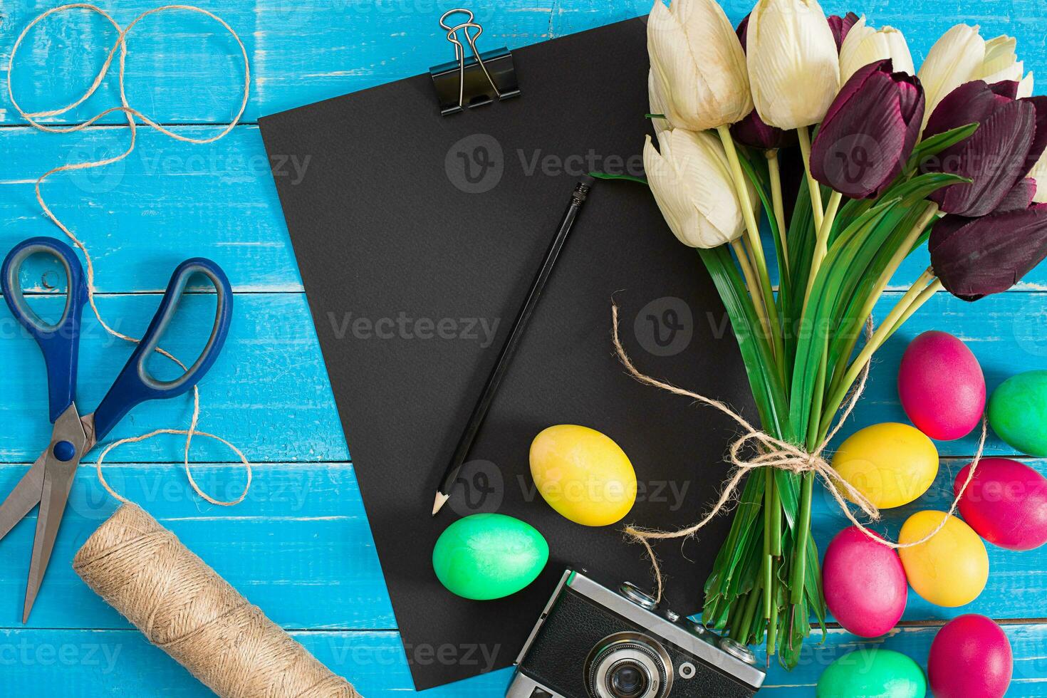 Easter eggs and tulips on blue rustic wooden planks photo
