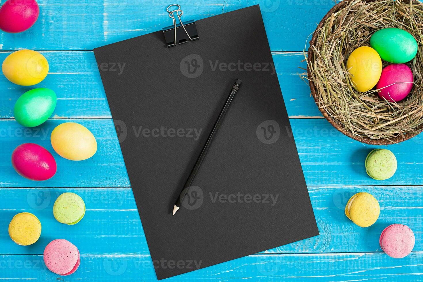 Easter eggs in nest on blue rustic wooden planks photo