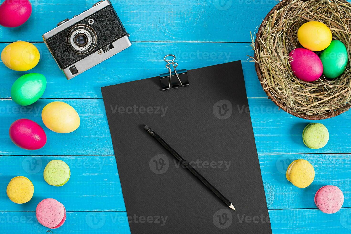 Easter eggs in nest on blue rustic wooden planks photo