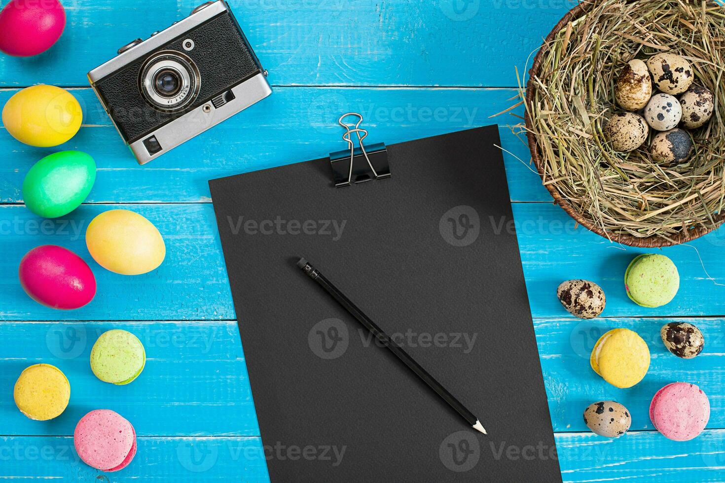 Easter eggs in nest on blue rustic wooden planks photo