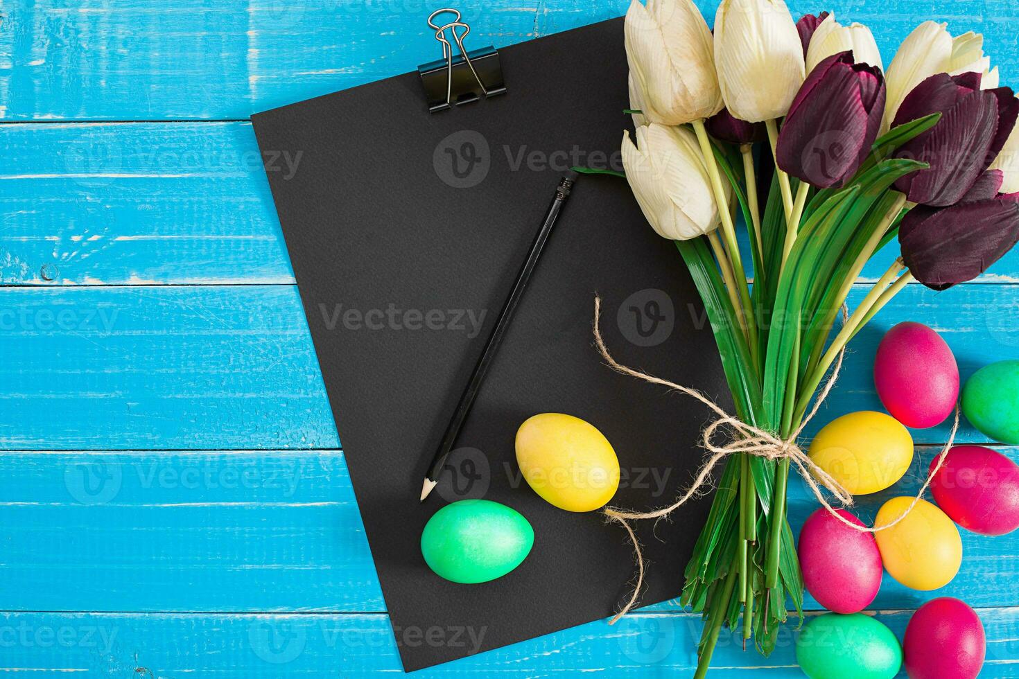 Easter eggs and tulips on blue wooden planks photo