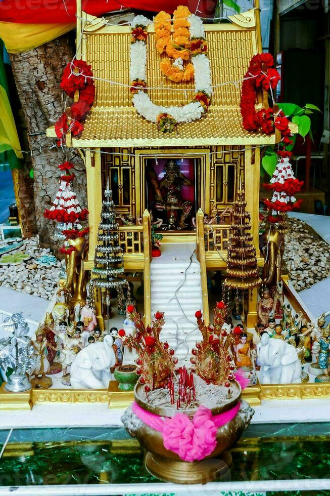 a small golden buddha house with decorations on top photo