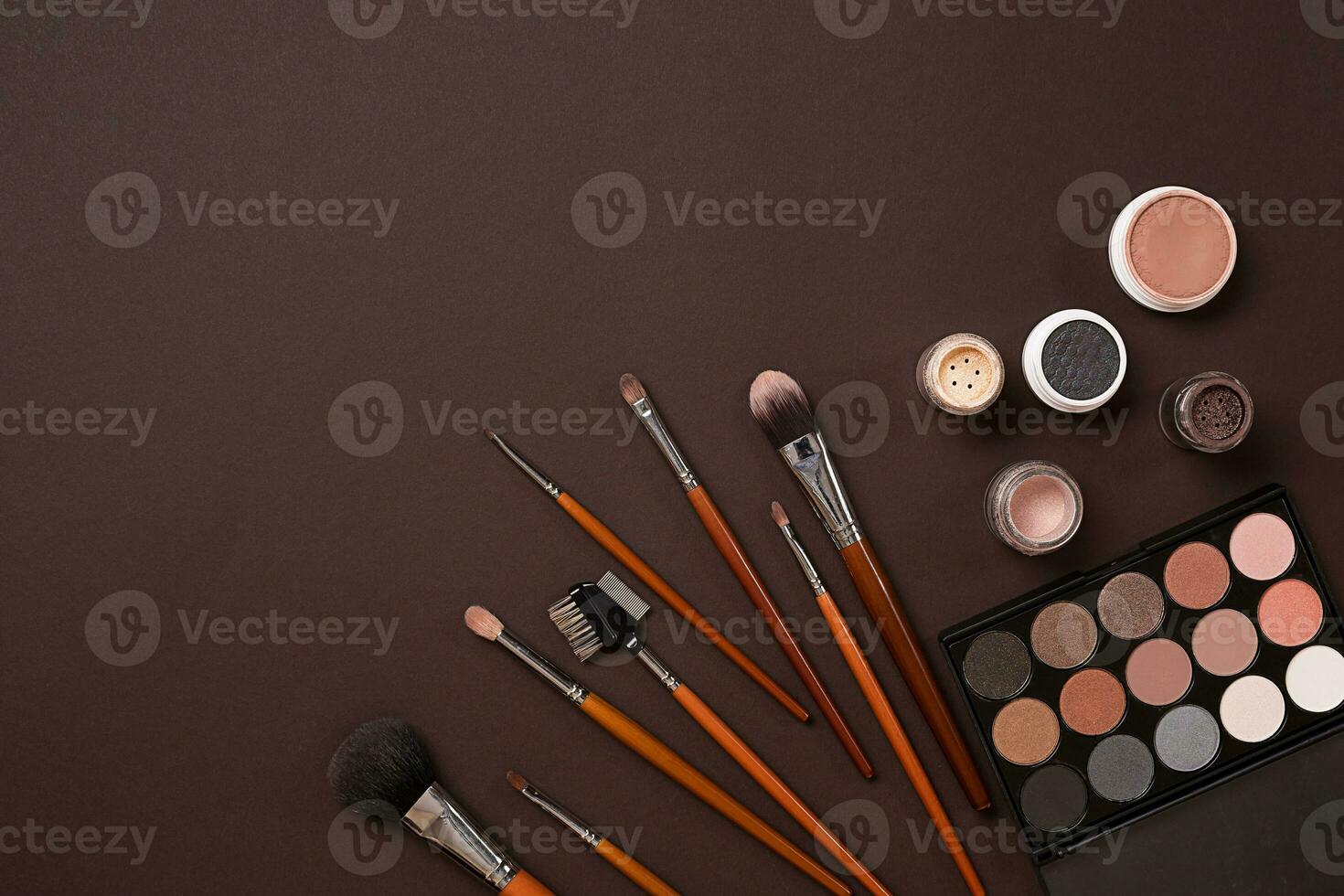 Various cosmetics and brushes on brown background photo