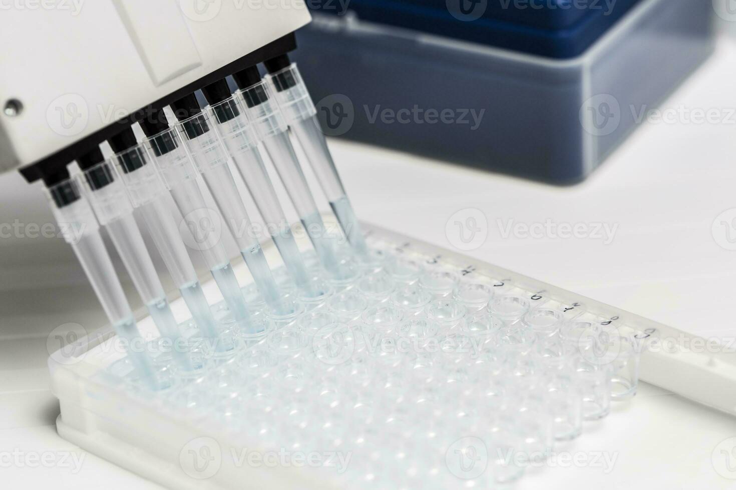 Pipette depositing samples into a 96 well micro-plate photo
