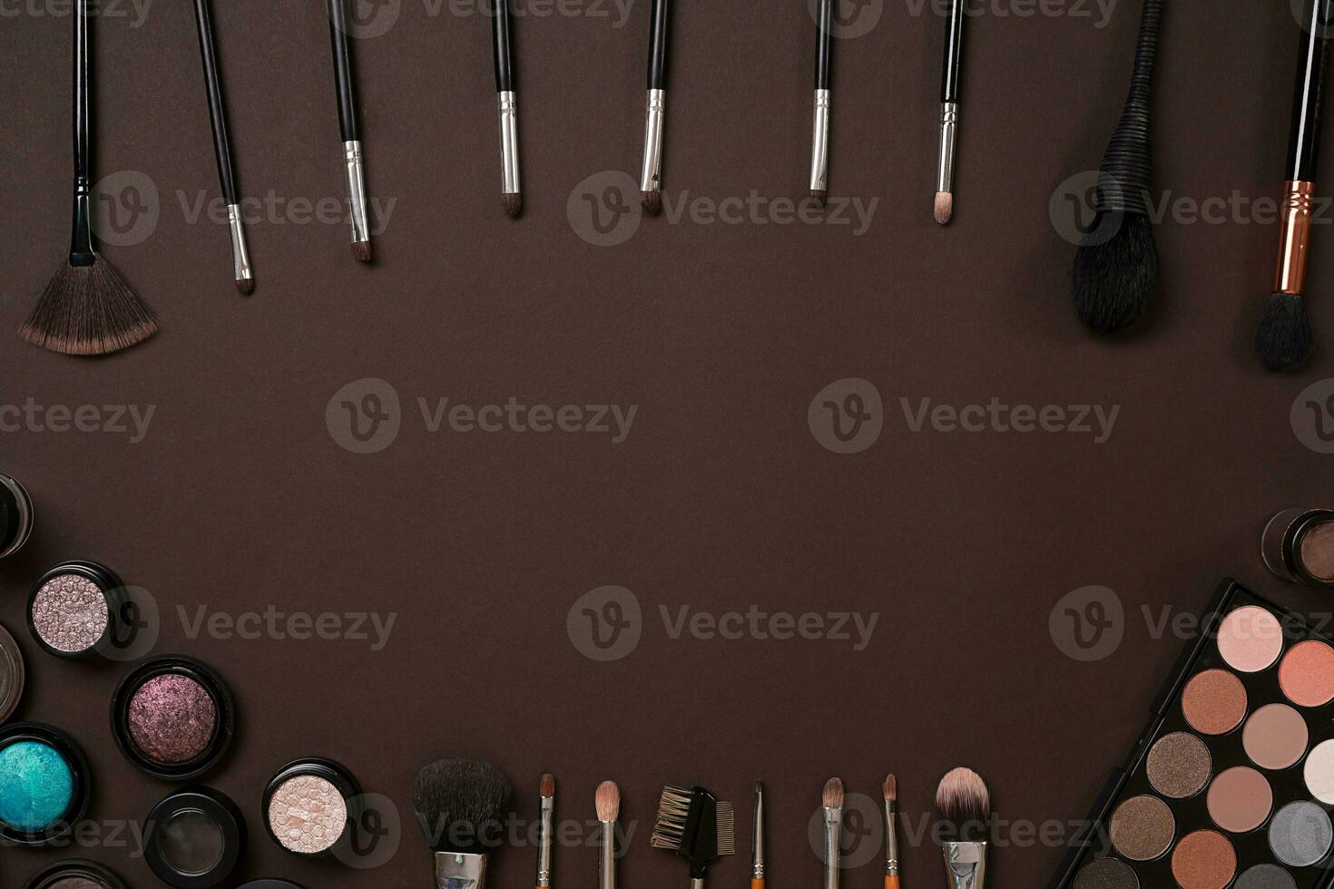 Make up essentials. Set of professional make up brushes, creams and shadows in jars on dark background. photo