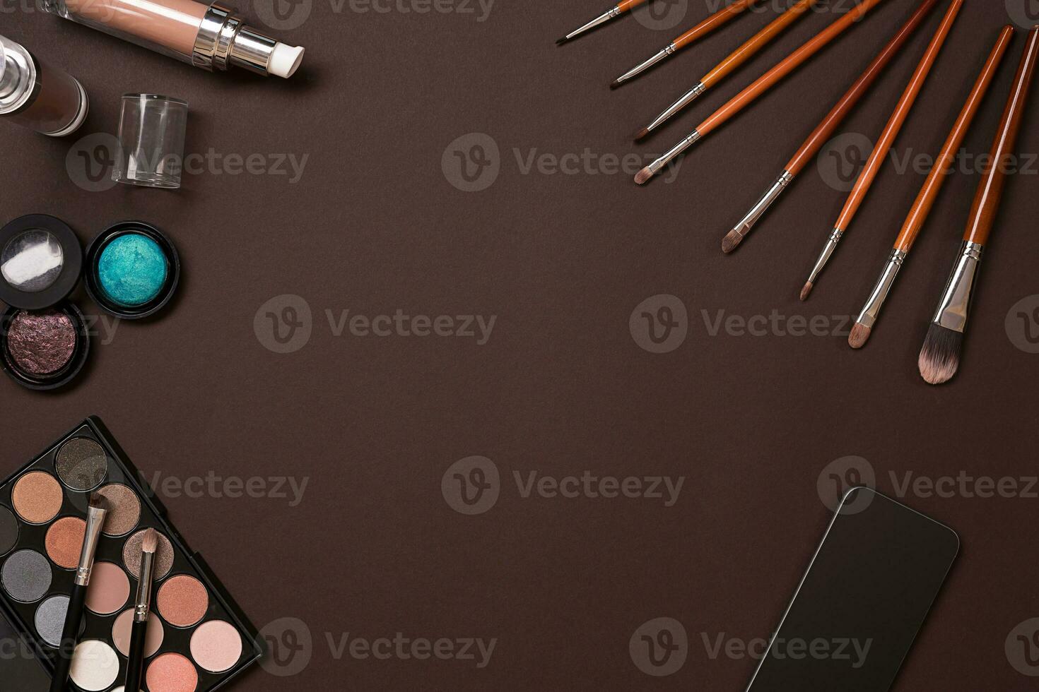Various cosmetics and brushes on brown background photo