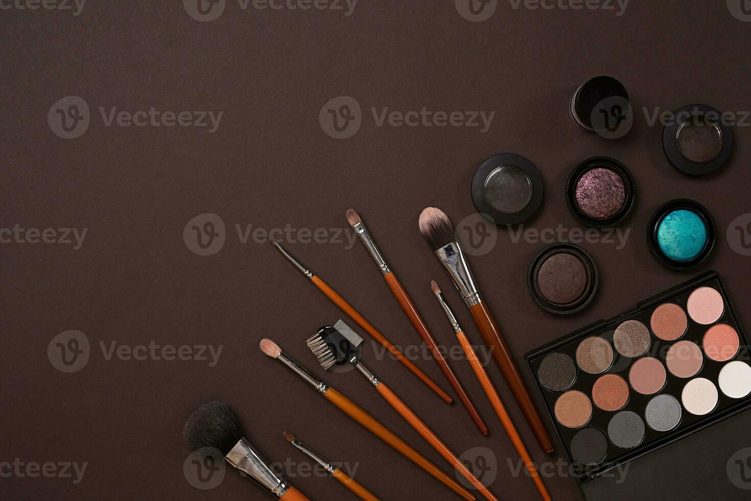 Make up essentials. Set of professional make up brushes, creams and shadows in jars on dark background. photo