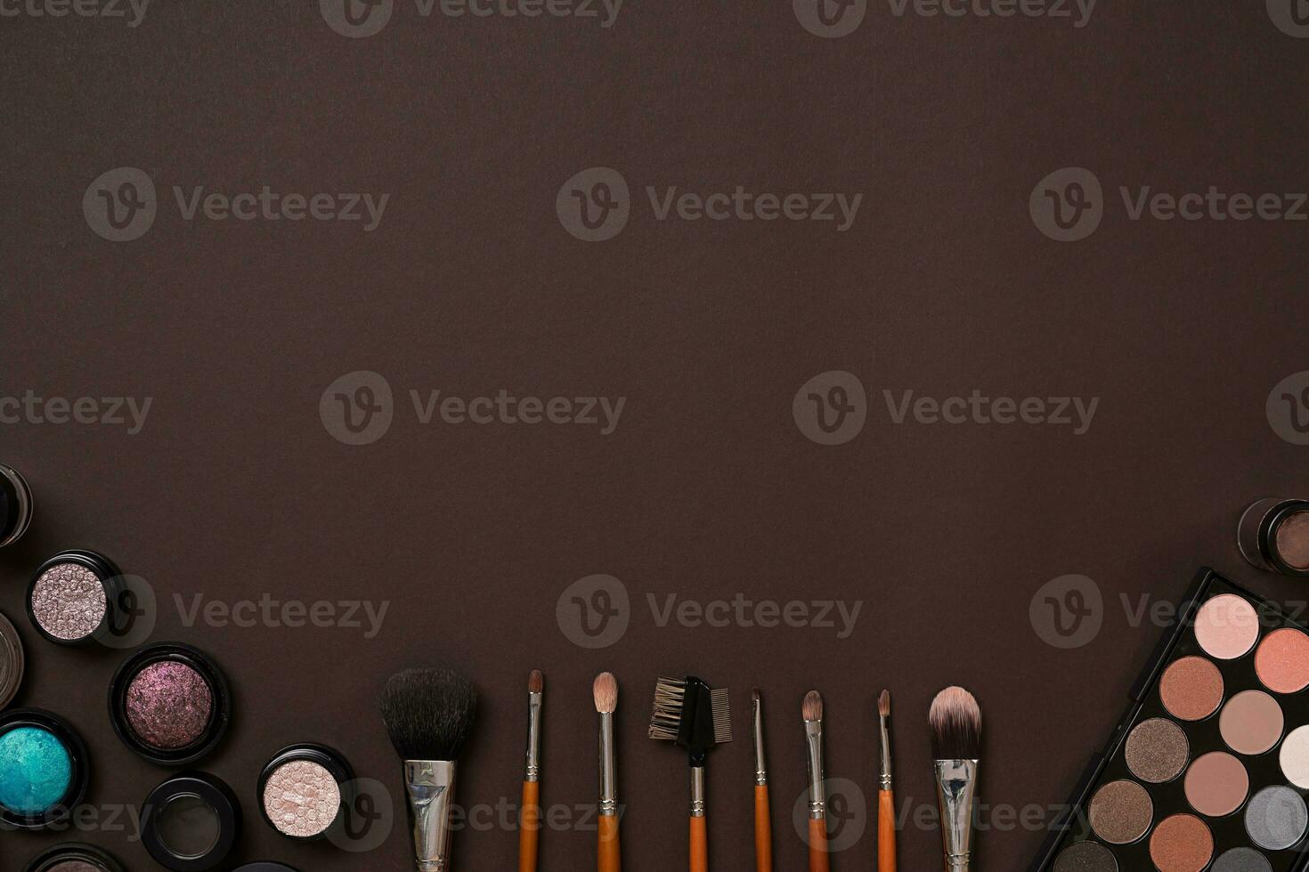 Various cosmetics and brushes on brown background photo