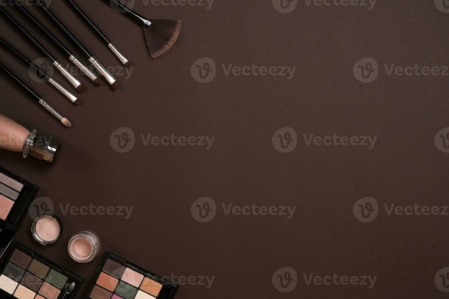 Various cosmetics and brushes on brown background photo