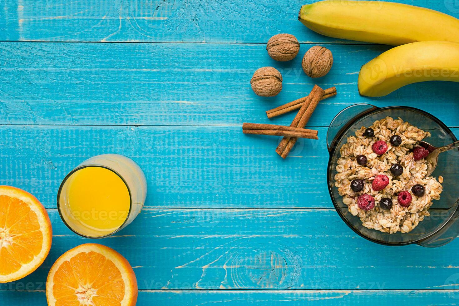 oatmeal porridge with banana, kiwi fruit, nuts and honey in a bowl with egg for healthy breakfast on rustic wooden background. top view photo