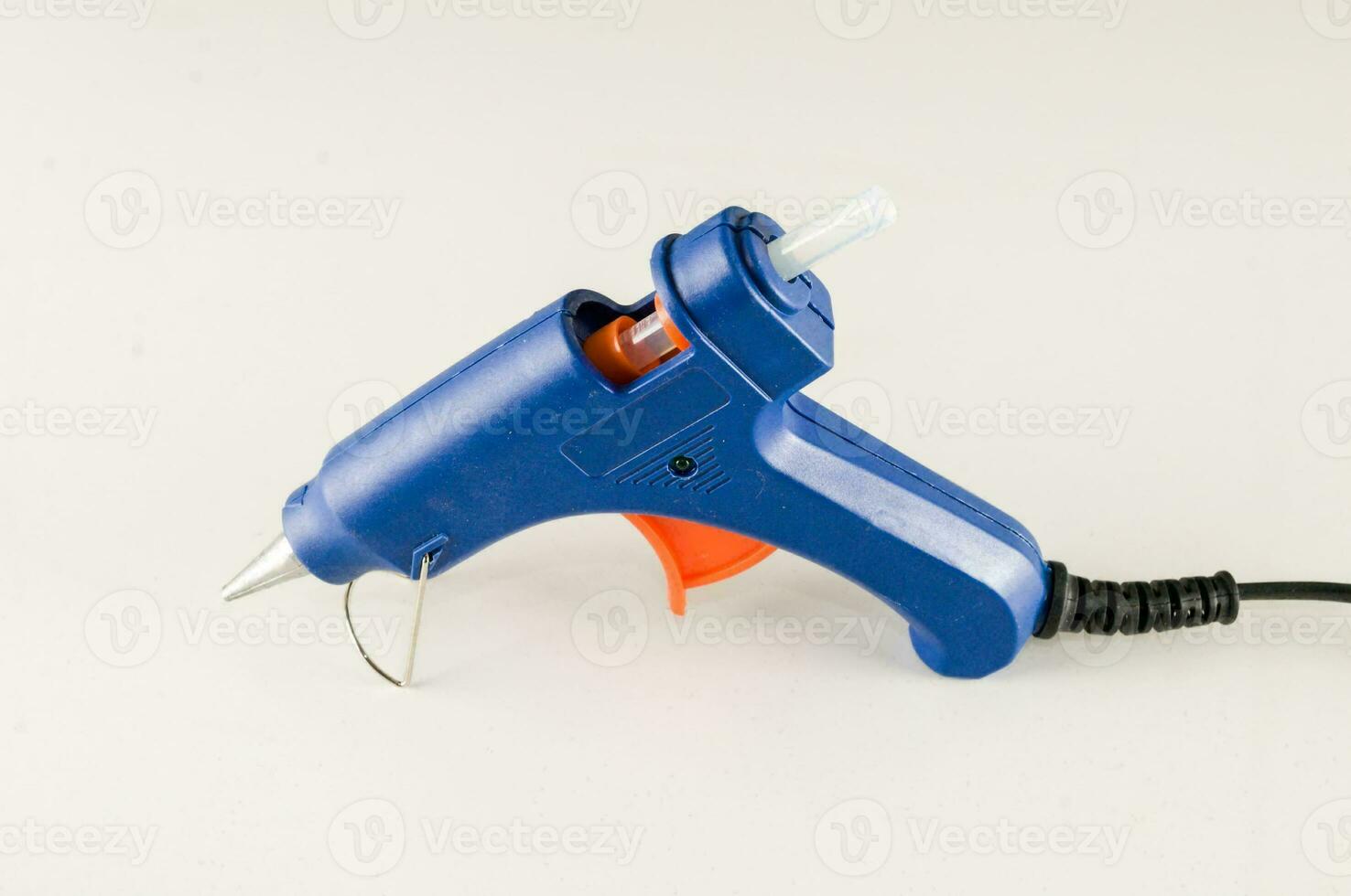 a blue and orange glue gun on a white surface photo