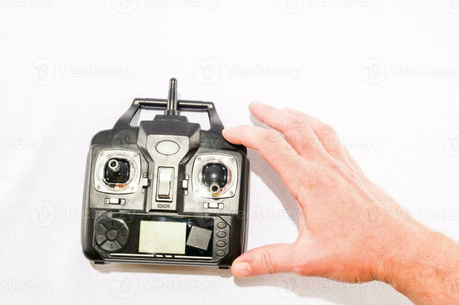 a hand holding a remote control device on a white background photo
