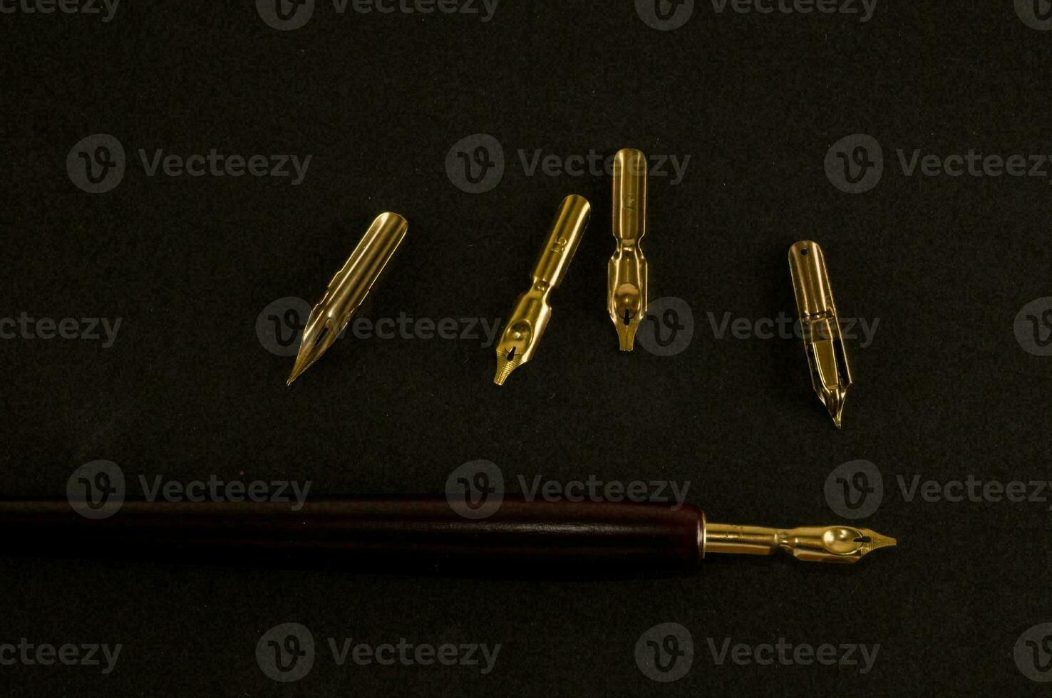 a pen with a gold nib and four other gold nibs photo
